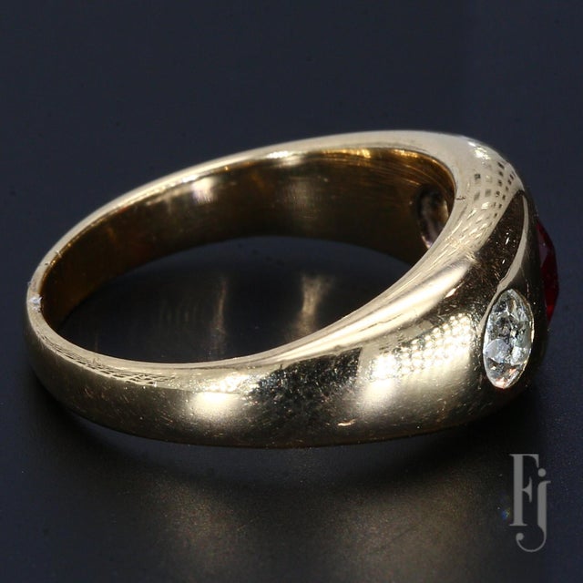 A 14k Yellow Gold Ring with a ~0.5ct Garnet Center Stone and Two Flush Set Diamonds weighing ~0.15cts each. Size - 6.25...