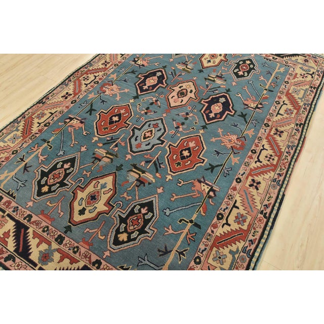 An authentic vintage tribal Heriz rug hand-knotted with fine wool on a cotton foundation. This rug features geometric...