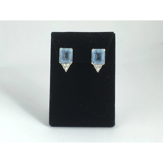 Beautifully made costume clip earrings with faceted emerald cut blue glass accented with 3 round shaped clear crystals on...