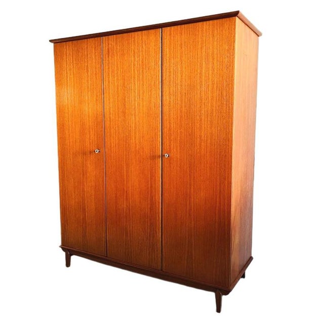 Beautiful vintage mid-century Danish design three-door teak wardrobe from the 1960s. This wardrobe has a beautiful teak...
