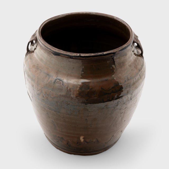 Coated inside and out with a rich drip glaze, this early 20th-century jar was originally used for storing foods and...