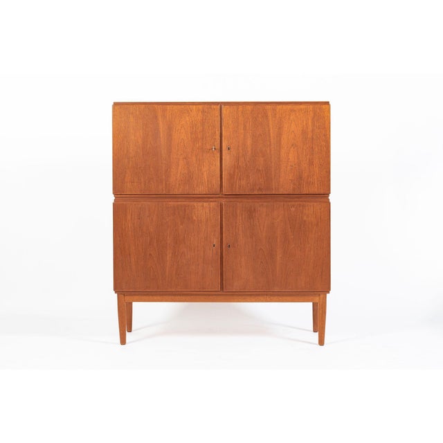 This vintage mid-century Scandinavian modern teak wood storage cabinet in the style of Torbjørn Afdal was made in Denmark...