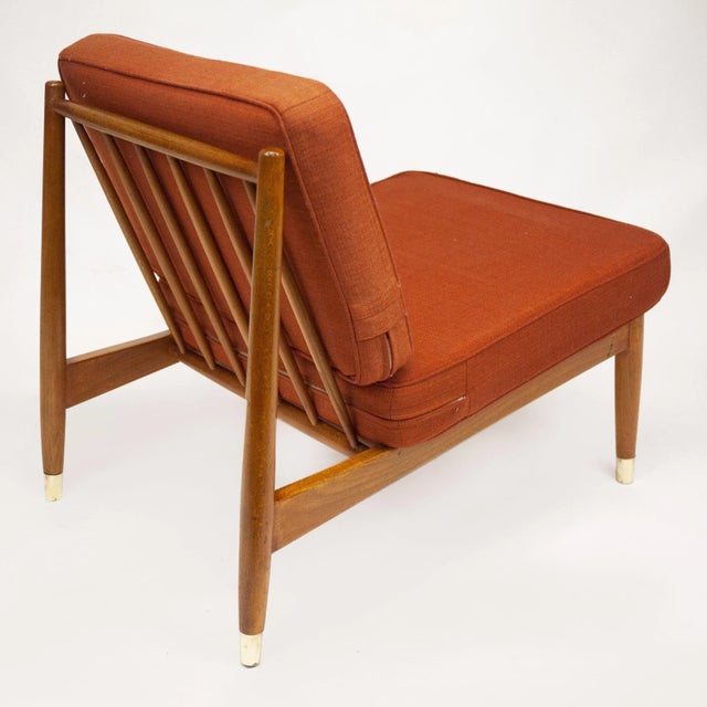 A beech lounge chair in original orange fabric by Folke Ohlsson. This piece is attributed to the mentioned designer/maker....