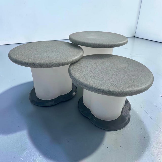 Set of three frosted lucite with stone top circular nesting tables. Each table has black acrylic bottoms with frosted...