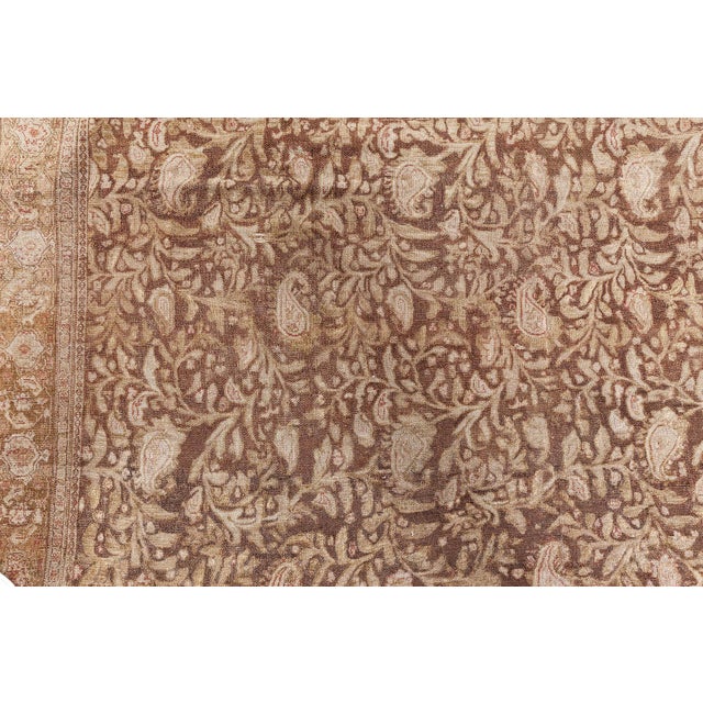 An early 20th century Persian Senneh two-toned antique rug, the cocoa field with beige flowering vinery and staggered...