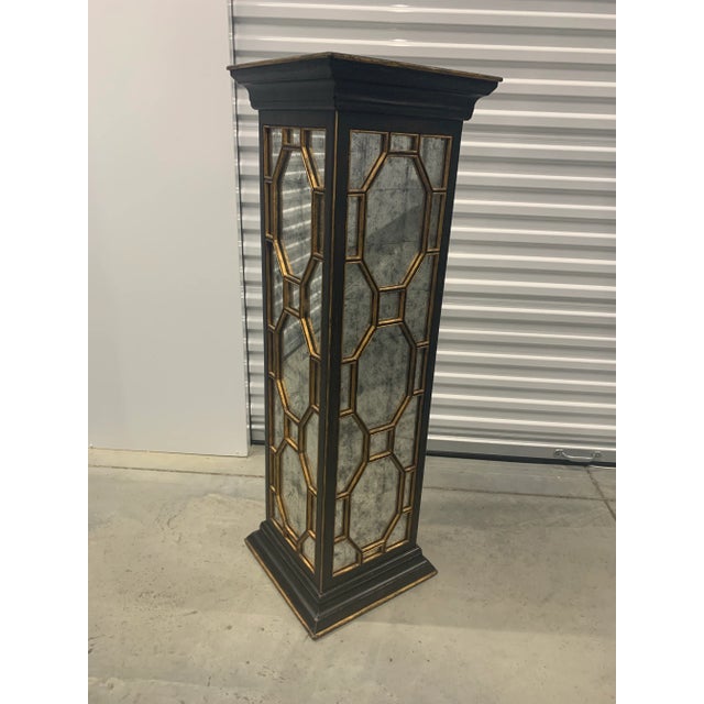 Distressed ebonized pedestal with gilded accents and an églomisé top and side panels covered by Chippendale Style fretwork.
