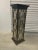 Distressed ebonized pedestal with gilded accents and an églomisé top and side panels covered by Chippendale Style fretwork.