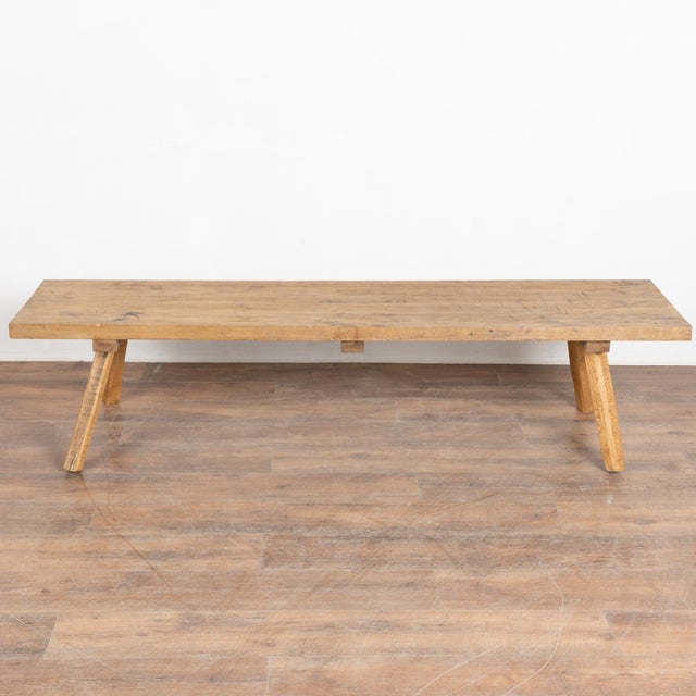 The appeal of this rustic coffee table comes from the thick wood top that originally served as a worktable. The splayed...