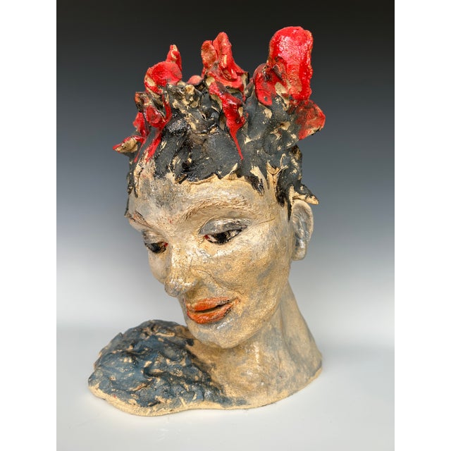 This beautifully crafted ceramic sculpture depicts a woman with a demure, contemplative expression. Red flowers adorn her...