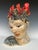 This beautifully crafted ceramic sculpture depicts a woman with a demure, contemplative expression. Red flowers adorn her...