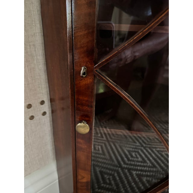Antique English Georgian corner cupboard in mahogany with fine detailing and brass decoration.