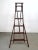 Wooden folding library ladder with tiered steps. Dark painted finish. A-frame construction with hinged top and spreader...