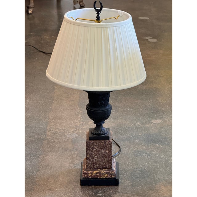 Pair of bronze and marble urn lamps. Each is formed as a classical campana urn in dark patinated bronze, the body cast in...