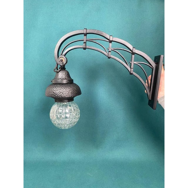 Black secession wall lamp with hammered decor and glass globe lampshade. Professionally stained and repolished, new wires....