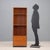 Small bookcase with drop-down compartment, adjustable shelves, in teak veneer. This piece is attributed to the mentioned...