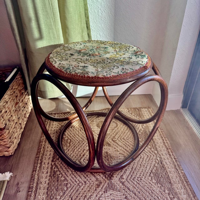 Vintage Thonet-style bentwood stool with a floral tapestry upholstered seat. The curved beechwood base has that iconic...
