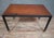 Modernist style coffee table, combining a solid wood top with a black lacquered metal frame, resting on four straight legs...
