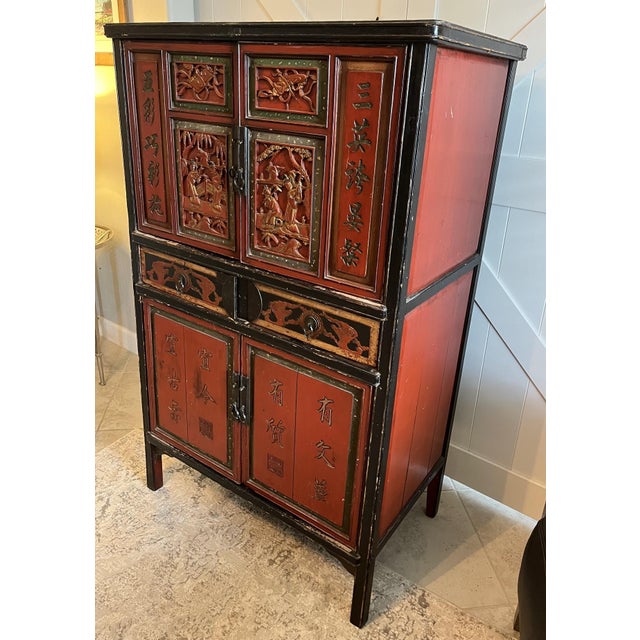 This exquisite late Qing Dynasty red lacquer wood wedding cabinet from the late 1800s features beautifully hand carved...