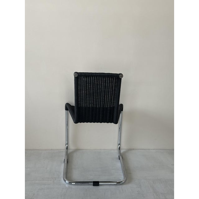 The D20 chair with armrests was designed by Jean Prouve and manufactured by TECTA. Its specially bent tubular frame and...