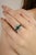 This Art Deco Inspired ring features a vibrant emerald cut emerald at the center, and blue sapphire weighing 2.34 carats,...
