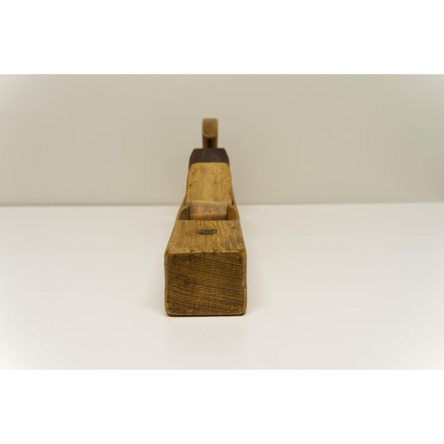 An antique 16" wood hand plane with a beautifully aged, timeworn patina. This particular plane, with its visible "I.Ph.K."...