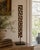 An early-20th-century iron architectural fragment composed of a continuous Greek key motif, now presented vertically on a...