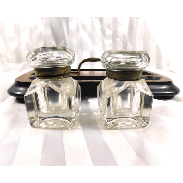 This is a wooden tray with a metal handle in the center. The tray has two long oval cut outs for pens and niibs and...