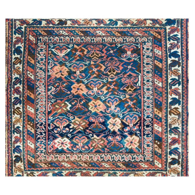 A charming and unique early 20th century Persian Afshar rug featuring a repeated stylized floral pattern, almost...
