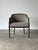 A black lacquered faux bamboo armchair with a barrel-shaped back, turned bamboo-style frame, and fretwork brackets at the...