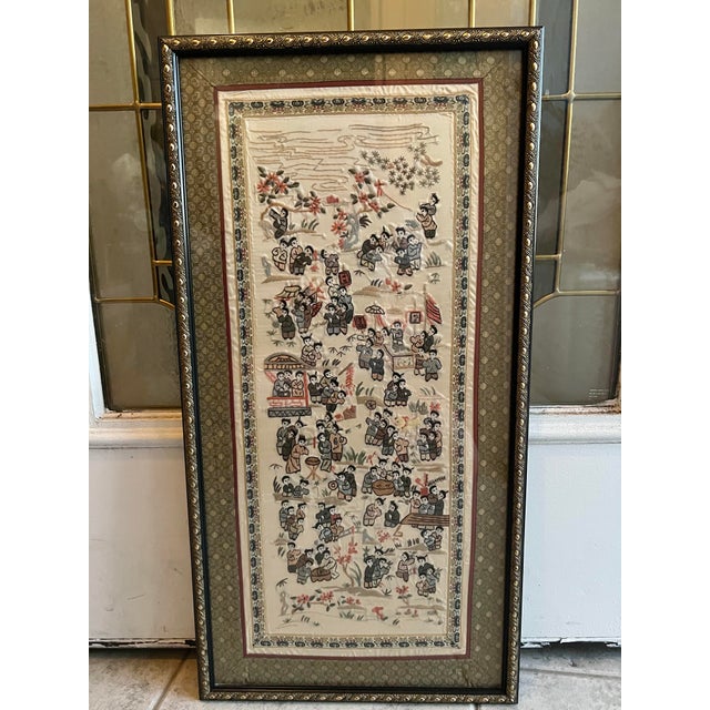 This is an antique framed silk panel. An Oriental, embroidered decorative scene known as the 'Hundred Children' dating to...
