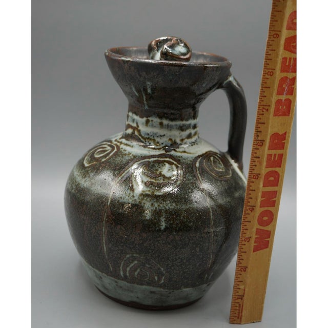 A visually commanding hand-thrown studio stoneware pitcher/ewer, approximately 8" tall, representing the highest level of...