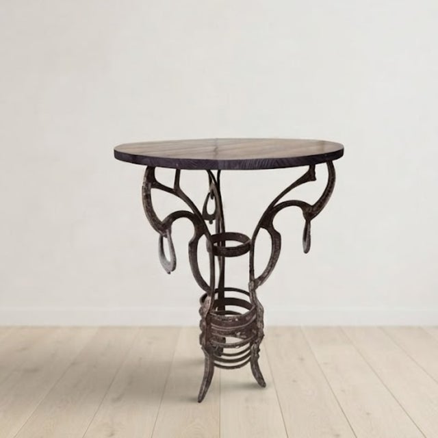 A distinctive handmade round side table featuring an ornate wrought iron base and a solid wooden top. Combining decorative...