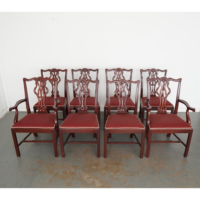 This vintage set of eight Chippendale-style dining chairs dates to the mid-20th century and includes six side chairs and...