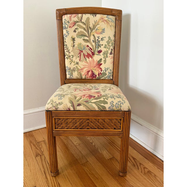 Vintage pencil reed side chair in a warm honey tone. Upholstered in cream fabric with pink, sage, and blue botanicals. In...