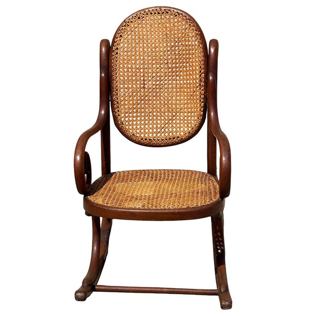 Turn of the century Vienna Secession oak child size rocking chair features an elegant, sculptural frame crafted from warm-...