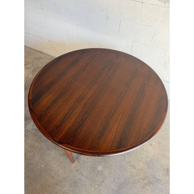 This beautiful oval dining table displays a highly streamlined form featuring tapered legs and a hidden center expansion...