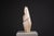 This sculpture stands tall with a commanding, architectural presence, shaped from a textured ceramic surface that brings...