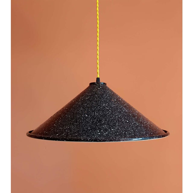 Vintage industrial sheet metal pendant light. Large conical shade in black and white speckled enameled sheet metal. Wired...