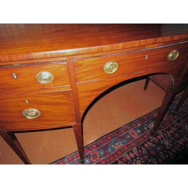 English Hepplewhite mahogany sideboard featuring cross band and string inlay and tapered legs with spade feet. Two deep...