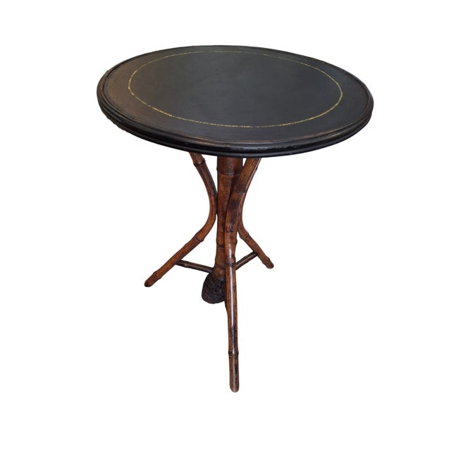 Vintage Victorian bamboo round side table with leather top. Table has 3 legs made from bamboo amd a large bamboo end in...