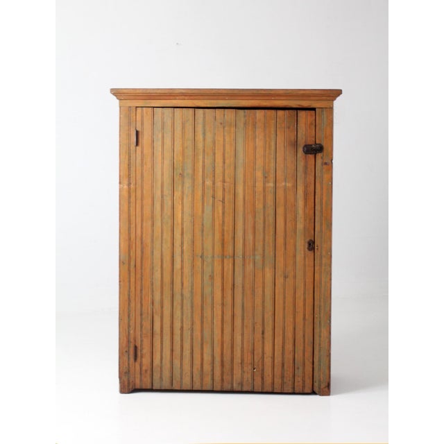 This late 1800s beadboard cupboard is full of rustic charm, featuring warm aged wood, traces of muted green paint, an...