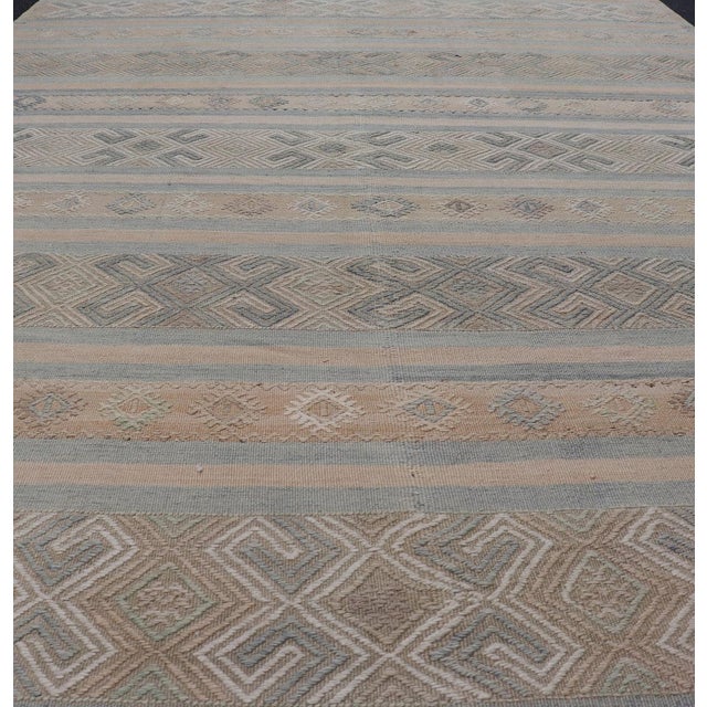 This flat-woven Kilim from Turkey features an enticing composition consisting of stripes with fascinating geometric...