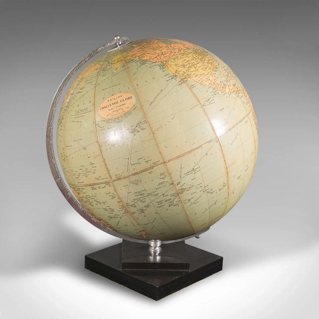 This is a vintage table globe. An English, paper finished world map with chrome meridian, dating to the mid 20th century,...
