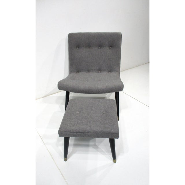 A Mid Century two piece set of a curved and super comfortable lounge chair and ottoman upholstered in a soft gray blended...