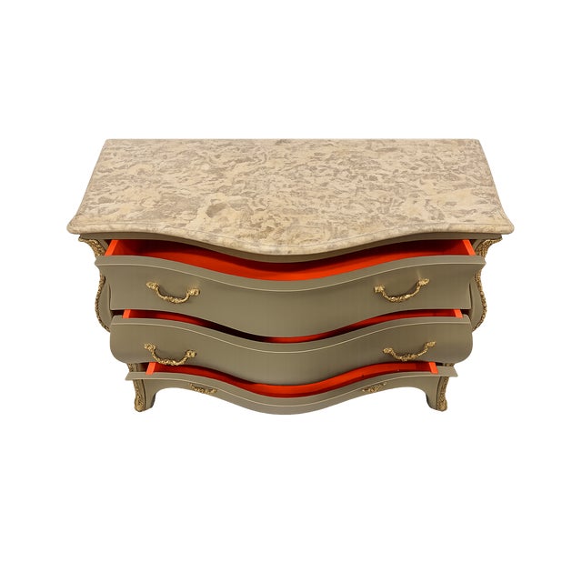 Walnut burl commode with brass hardware and handles and honed travertine top. The classic bombe silhouette is reimagined...