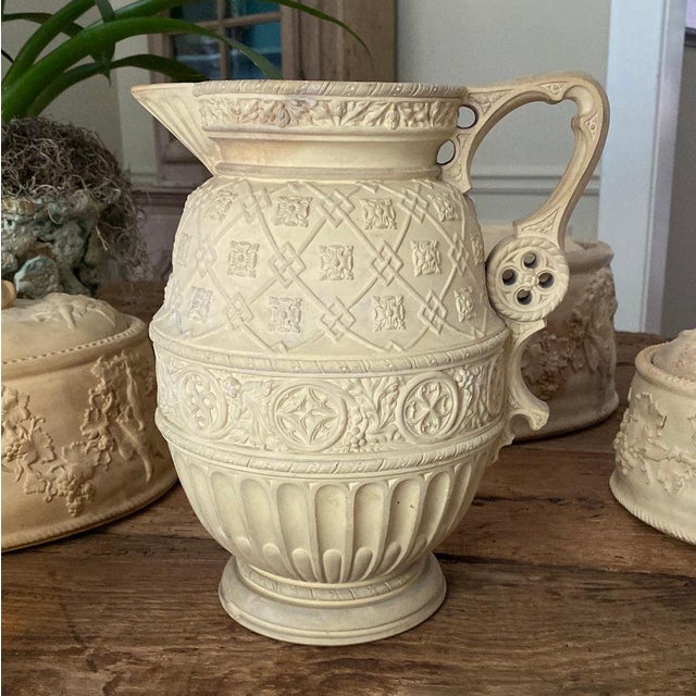 19th c Caneware jug with elaborate relief decorations and distinctive ornamental handle. Found in England. No makers mark....