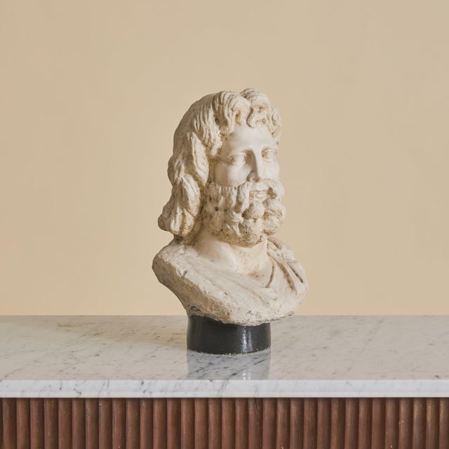 A 20th Century French plaster bust sculpture, likely representing Zeus, modeled in the classical tradition. The figure is...