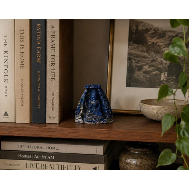 A finely hand-carved sculpture in natural fine grades lapis lazuli depicting the Buddha seated within an ornate alcove...