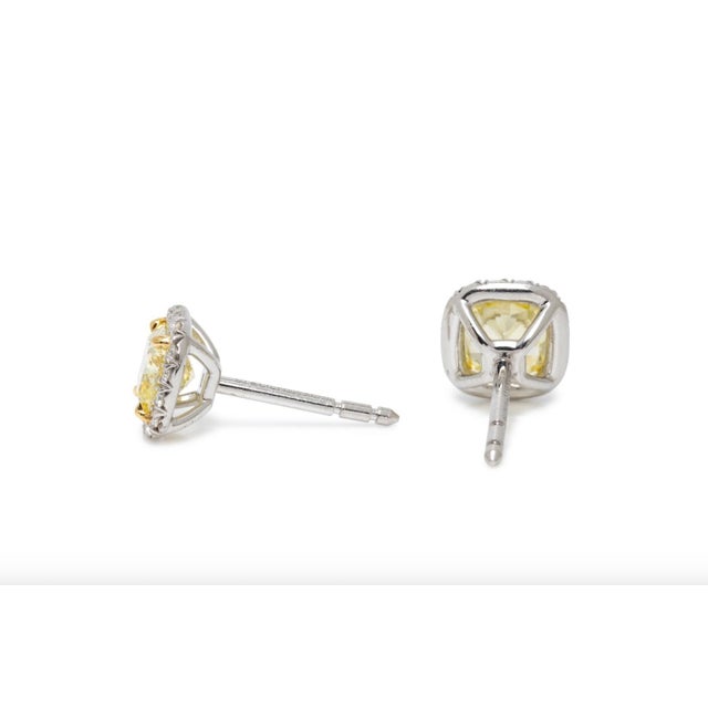 A pair of exquisite Tiffany & Co. Soleste stud earrings, showcasing two 1.46 carats cushion shaped Fancy Intense Yellow...