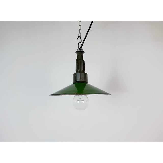 Industrial green enamel pendant light made in Poland during the 1960s. White enamel inside the shade. Green cast aluminium...